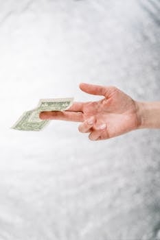 Close-up of a hand holding a one dollar bill, symbolizing finance or payment.